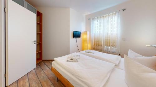 宾茨Villa am Kurpark的一间卧室配有两张白色的床和镜子