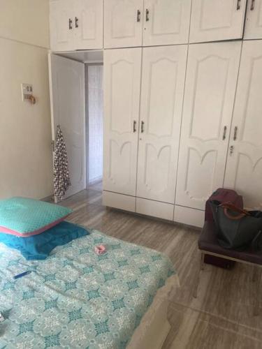 孟买Boho connection的一间设有一张床、白色橱柜和圣诞树的房间