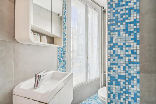 巴黎托尔比亚克酒店的一间带水槽和卫生间的浴室以及窗户。