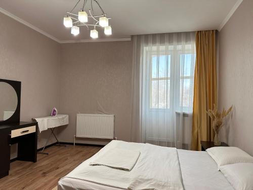 乌拉尔斯克Уютная рядом с парком的一间卧室配有一张床、一张书桌和一个窗户。