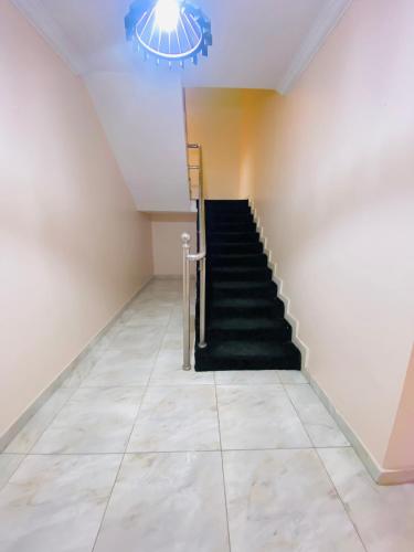 拉各斯Eden Haven的一间铺有瓷砖地板并配有吊灯的客房的楼梯