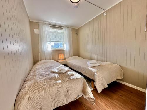 莱克内斯Leknes Airport Apartment的小型客房 - 带2张床和窗户