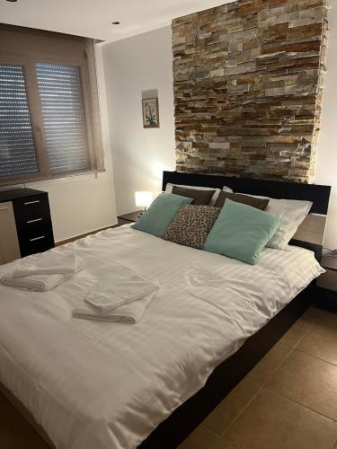 卡瓦拉Peaceful Escape的卧室配有一张白色大床和石墙