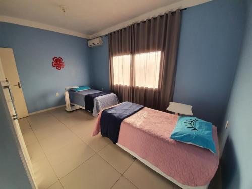 阿雷格里港Casa-Ampla Porto Alegre-RS的一间卧室设有两张床和窗户。