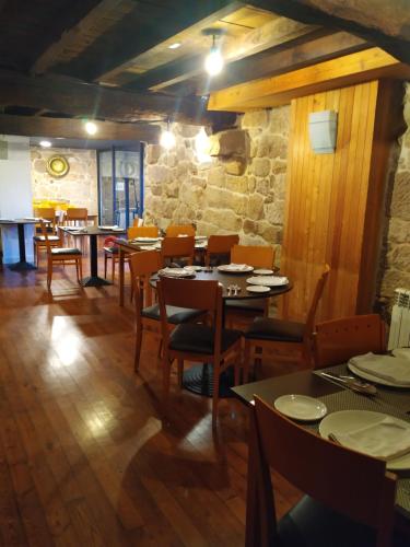 阿拉力兹Pensión rural Pallabarro的一间带桌椅和石墙的餐厅