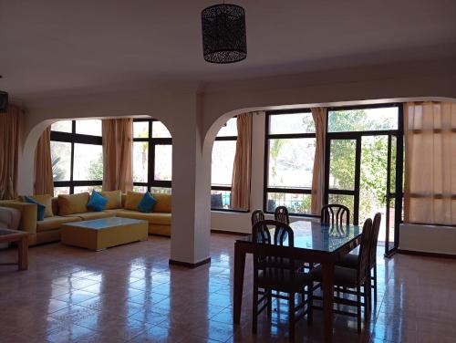 奥比丹Villa El Ghriss的客厅配有桌椅和沙发