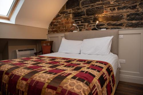 多尼戈尔Donegal House的一间卧室设有一张床和砖墙