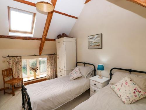 纳伯斯1 Mill Farm Cottages的一间卧室设有两张床和窗户。