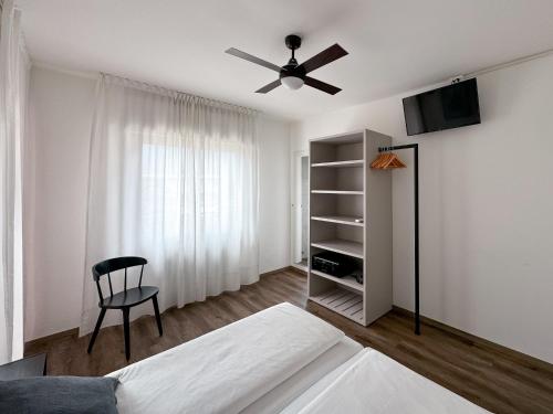 托尔博莱Villa Paola B&B的一间卧室配有一张床、一台电视和一把椅子