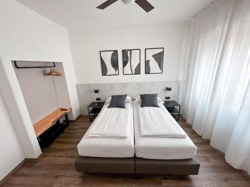 托尔博莱Villa Paola B&B的配有2张床的白色墙壁和窗户客房