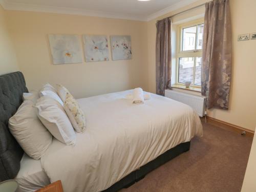 阿尼克Nook Cottage的卧室配有带白色枕头的床和窗户。