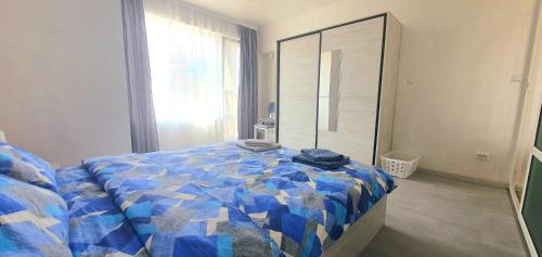 索非亚Апартамент Синчец的一间卧室配有一张带蓝色被子和镜子的床