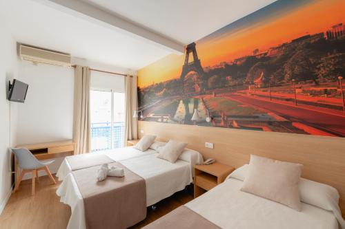 贝尼多姆国际酒店的酒店客房设有两张床,墙上挂有绘画作品