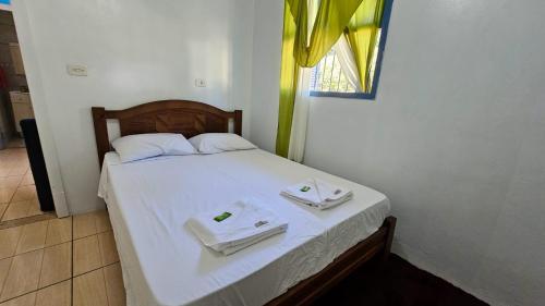 本图贡萨尔维斯Casa de Campo em Bento Gonçalves的一间卧室配有一张床,上面有两条毛巾