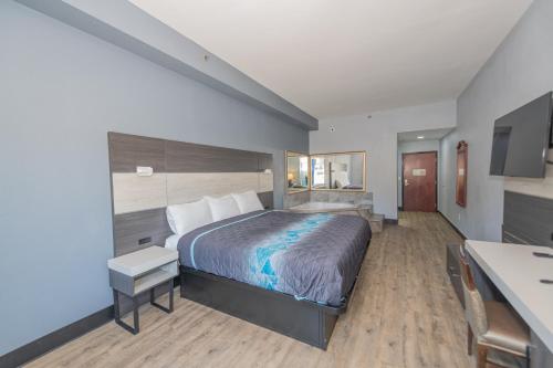 里弗代尔Jamestown inn & Suites的配有一张床和一张书桌的酒店客房