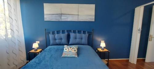 Grado-PinetaSeaview Beach Front Grado Pineta Andromeda的蓝色卧室配有蓝色的床和两盏灯
