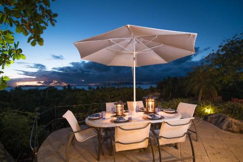西班牙镇On The Rocks Villa的露台上的桌子和遮阳伞