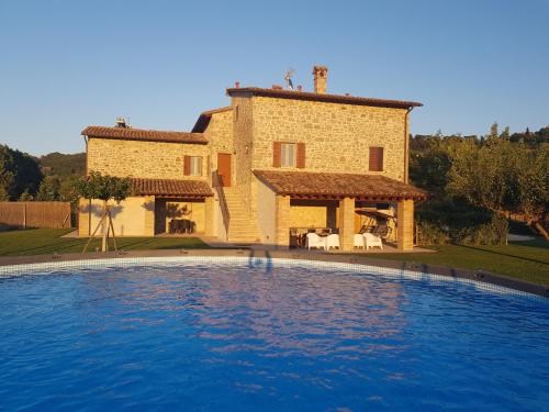 托迪Agriturismo Villa al piano的一座房子前面设有一个大型游泳池