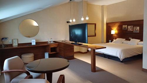 拉瓦克拉圣雅各之路酒店的酒店客房配有一张床和一张书桌及一台电视