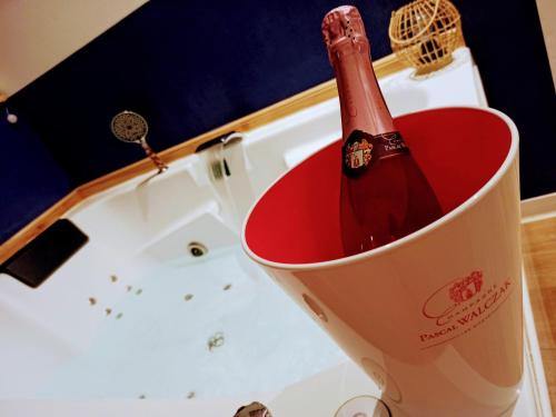 芒通Studio cosy, grand spa privatif et parking privée Centre ville menton的浴缸旁的桶里一瓶香槟