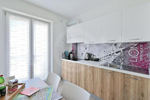 奥斯塔Le Lion Apartments - Lys Family Apartment的厨房配有白色橱柜和桌椅