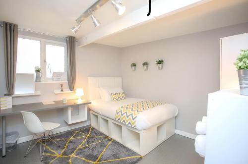 卢顿New Modern Room With En Suite Park Street Room 2的白色卧室配有书桌和床