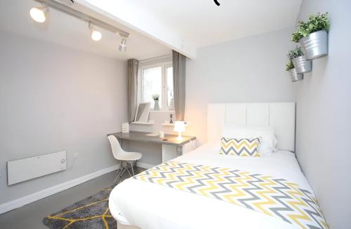 卢顿New Modern Room With En Suite Park Street Room 2的白色卧室配有床和书桌