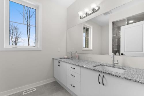 亨茨维尔Muskoka Retreat Stunning Hilltop Views的白色的浴室设有水槽和窗户。