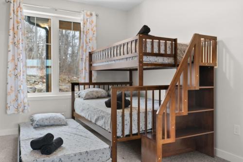 亨茨维尔Muskoka Retreat Stunning Hilltop Views的带两张双层床和楼梯的客房
