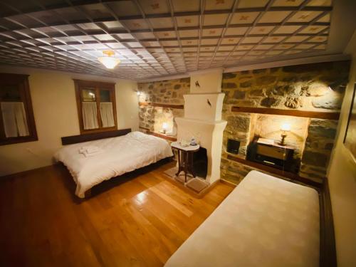 阿尔奈阿Aristotelous Alexandrou Historic Inn的一间卧室配有一张床和一个石头壁炉