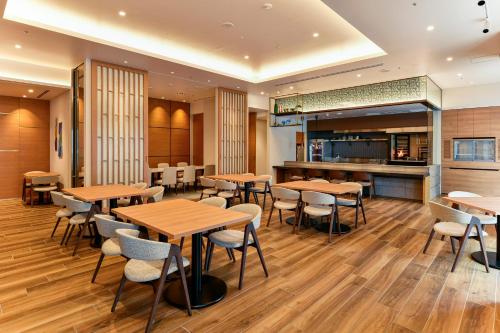 宫崎宫崎市酒店的配有木桌和椅子的餐厅