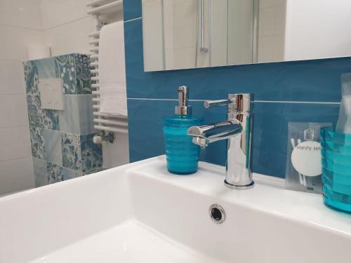 卡斯特里尼亚诺德尔卡波Le Stanze del Salento的浴室水槽设有水龙头和蓝色的墙壁