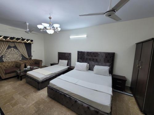 卡拉奇Hotel Capital one的一间带两张床和一张沙发的卧室