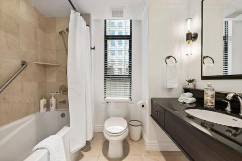 温哥华Elegant & Luxury 2 Bed Suite Close to Convention Centre的浴室配有盥洗盆、卫生间和浴缸。