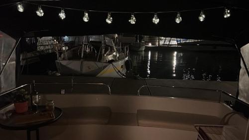 巴塞罗那Cosy and Homey Houseboat Castelldefels的港口里的船只,有桌子和灯