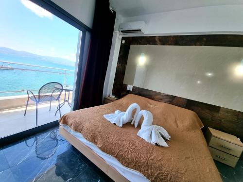 阿马林索斯波尔图埃维亚精品酒店 的窗户间内床边的2条天鹅毛巾