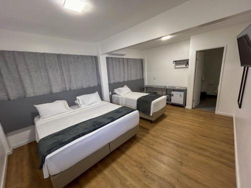 大坎皮纳Hotel do Vale的酒店客房设有两张床和一台平面电视。