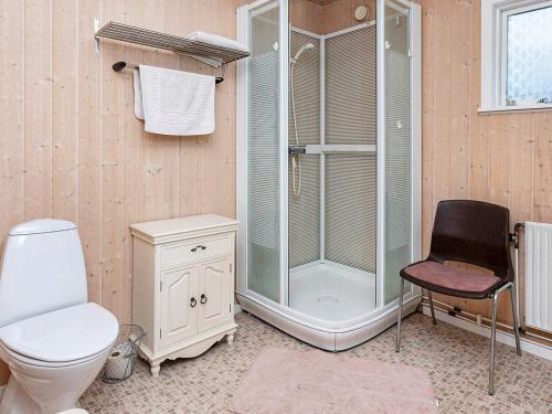 蒂霍尔姆Holiday home Thyholm XIX的带淋浴、卫生间和椅子的浴室