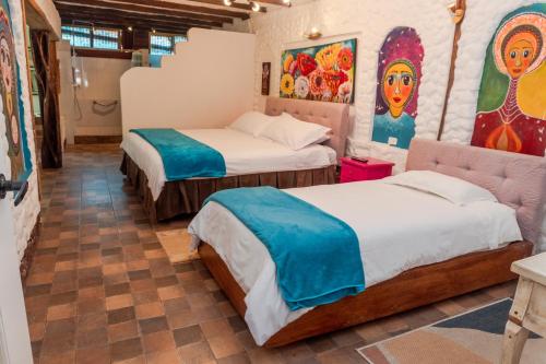 巴尼奥斯米拉梅林多Spa酒店的墙上画作的房间里设有两张床