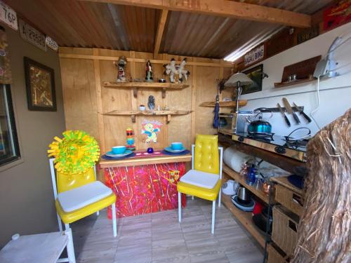 塞多纳Sedona Camp Tiny House的厨房配有2把黄色椅子和桌子