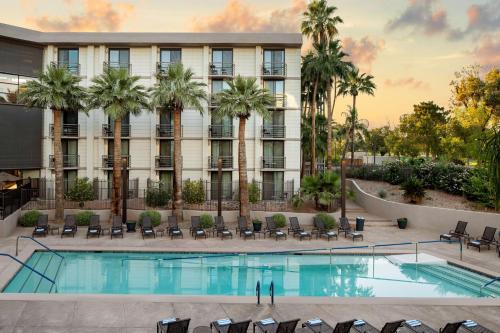 凤凰城Embassy Suites by Hilton Phoenix Biltmore的一张拥有游泳池和棕榈树的酒店形象