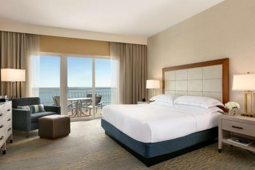 大洋城海滩城市希尔顿套房酒店的酒店客房设有一张床和一个阳台。