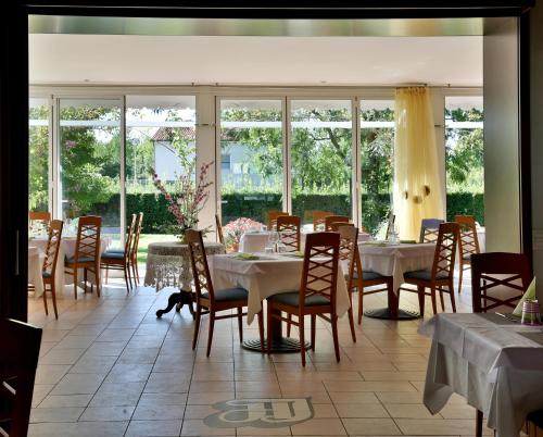 蒙法尔科内意大利酒店的用餐室设有桌椅和窗户。