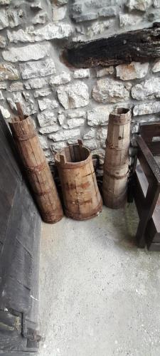 培拉特Villa Maria - Berat Castle的三个木桶,坐在石墙旁边