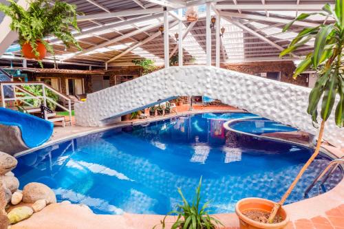 巴尼奥斯米拉梅林多Spa酒店的一座建筑物内一座带桥梁的游泳池