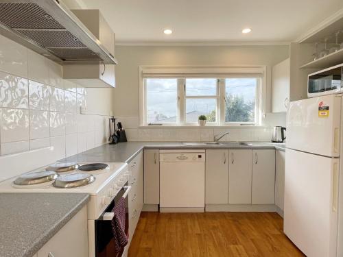 奥克兰Home in central Auckland的厨房配有白色家电和白色冰箱