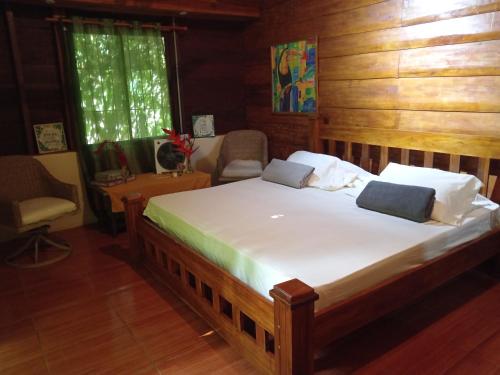 Puerto ViejoFinca La Paz的一间带一张大床的卧室,位于带木墙的房间