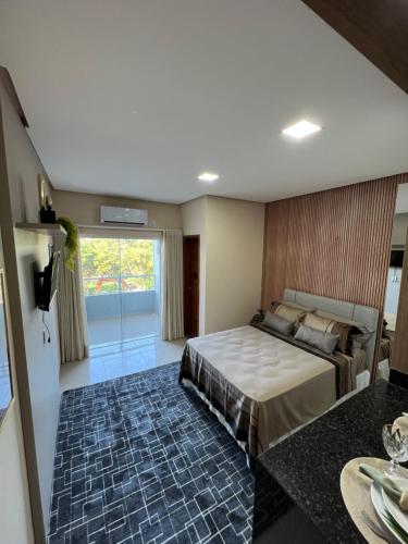 阿尔特杜尚Flat Moderno Ilha Bela的一间卧室设有一张床和一个大窗户