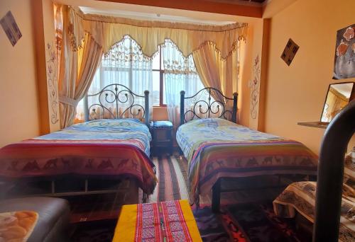 乌尤尼Hostal Golden Quinua的带窗户的客房内的两张床