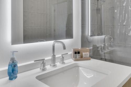 华盛顿Fully Furnished Apartment in Washington near Logan Circle的浴室水槽配有镜子和1瓶肥皂